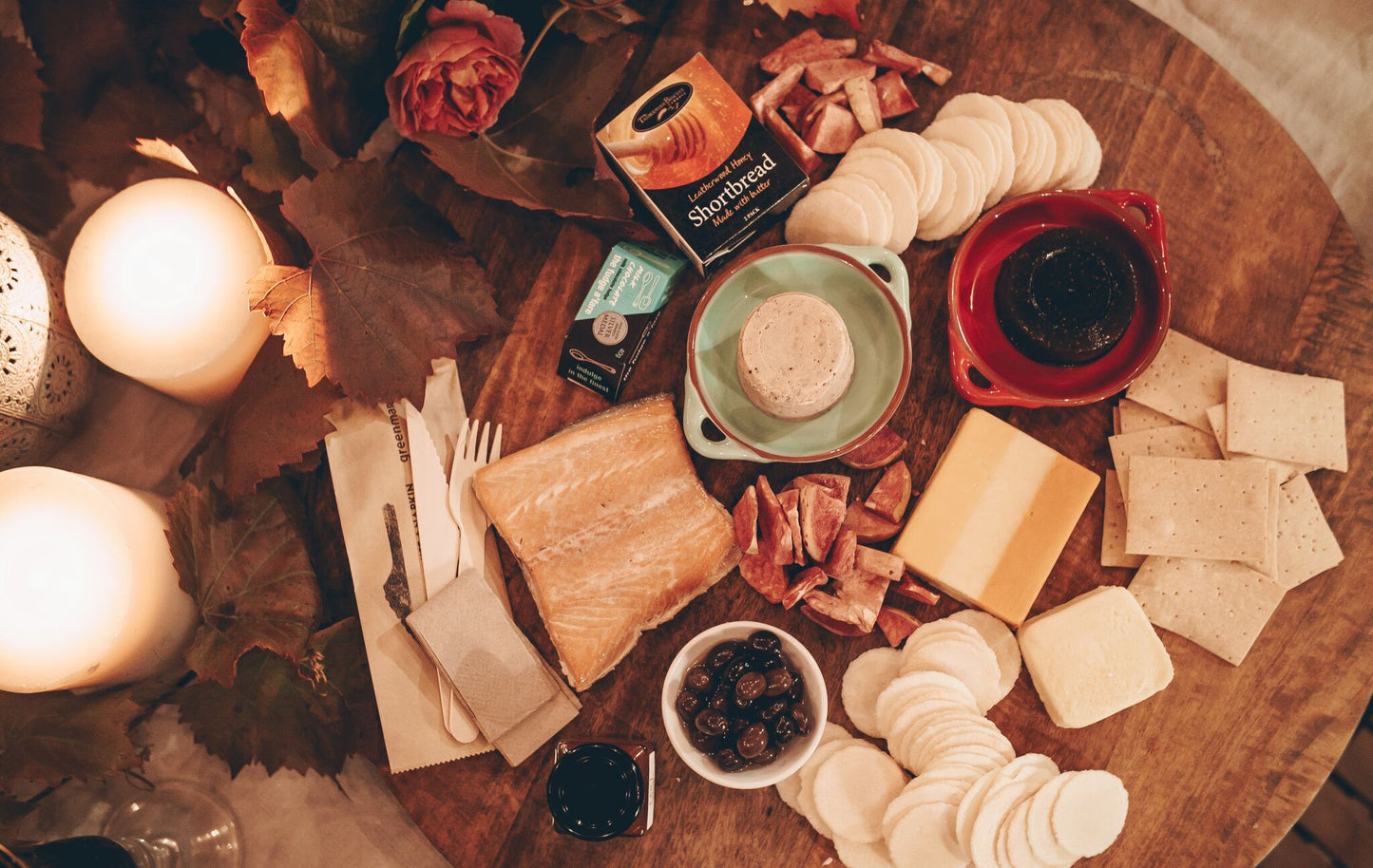 A top down photograph of yummy Taste of Tasmania tray items like smoked salmon, cheeses, crackers, and quince paste