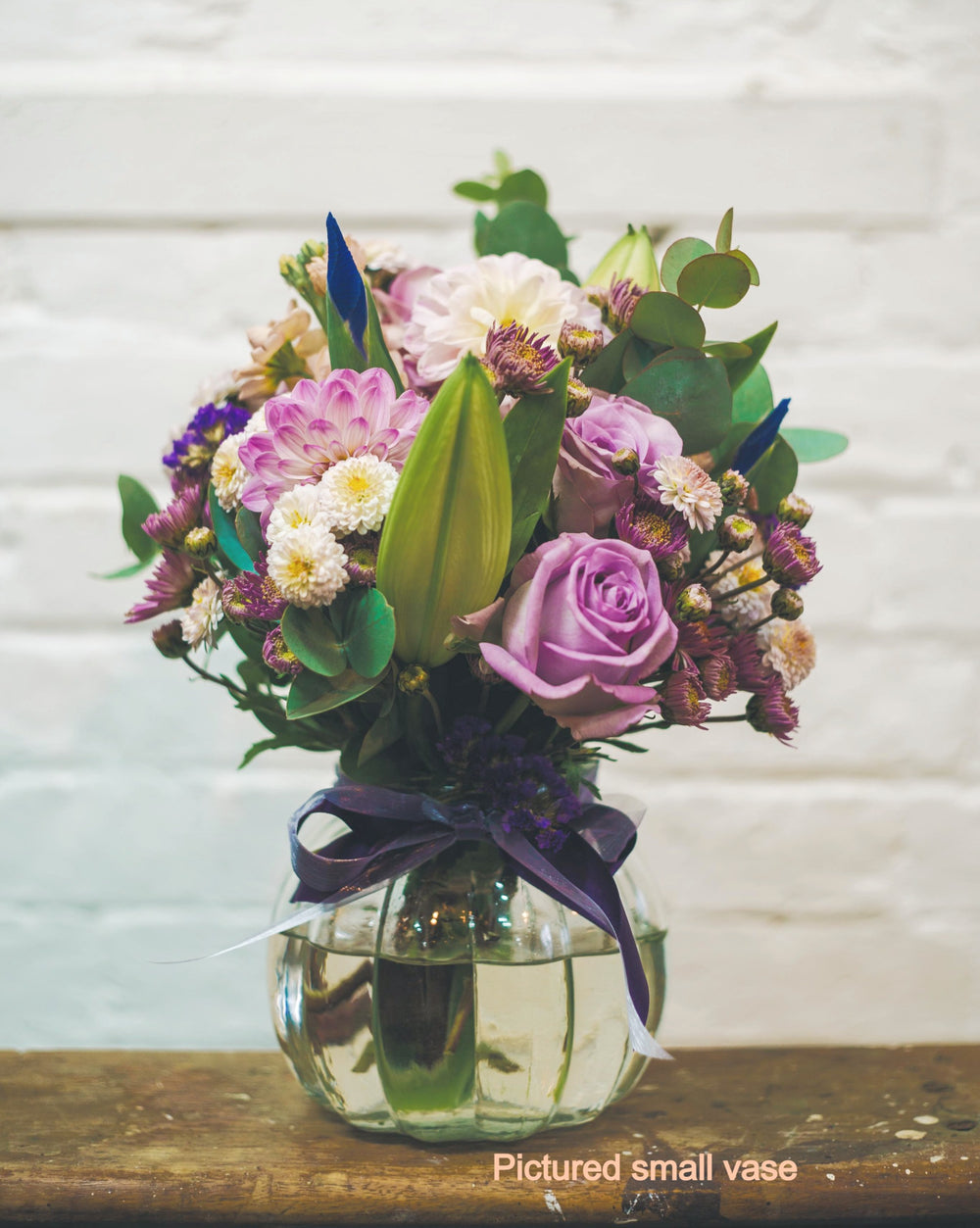 Picture of purple pastel flowers in a small glass vase