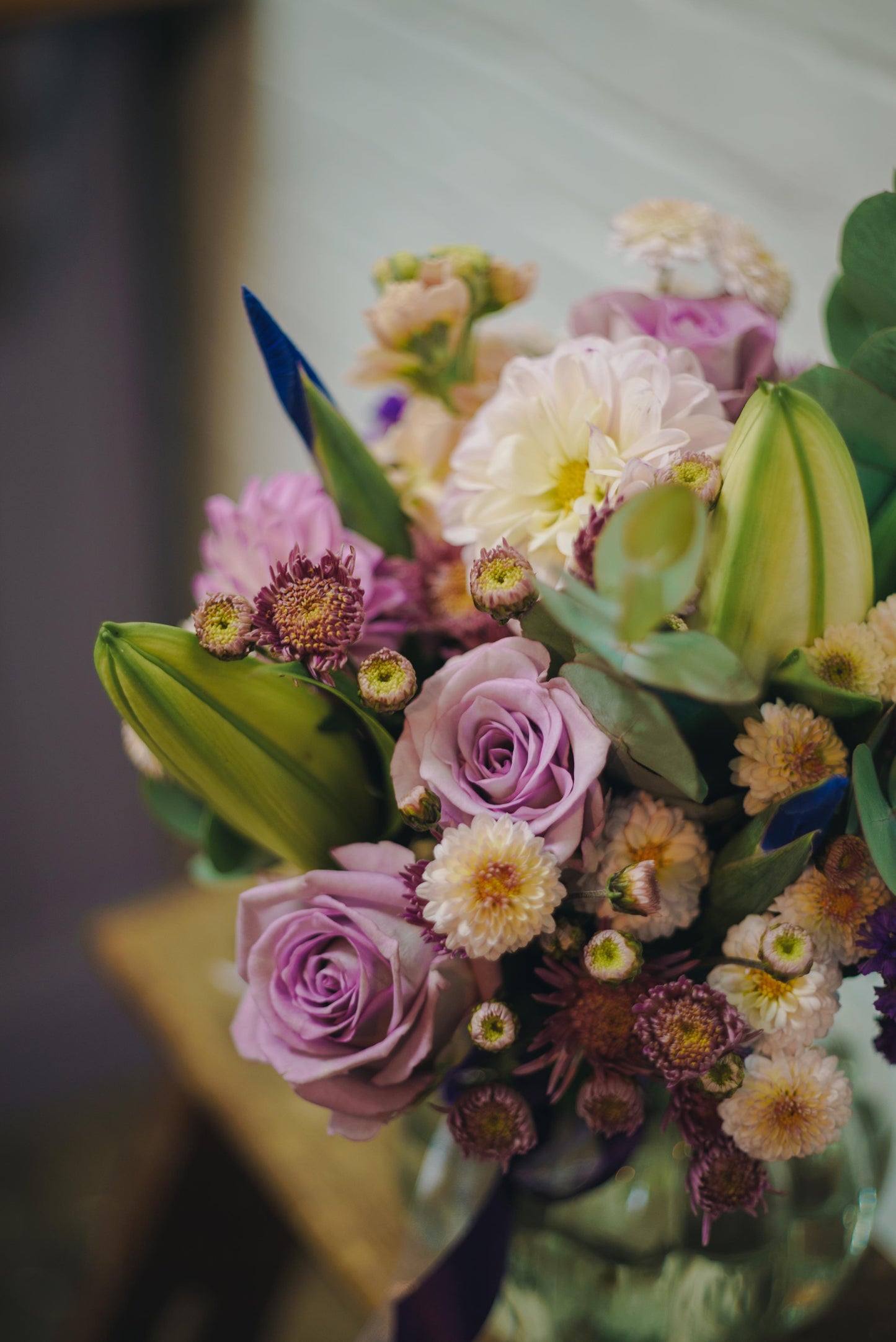 
                  
                    Close up of purple roses, lilies and daisies
                  
                