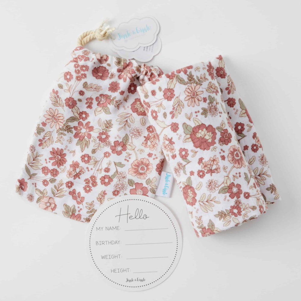 
                  
                    Photograph of a delicate floral muslin baby wrap 
                  
                