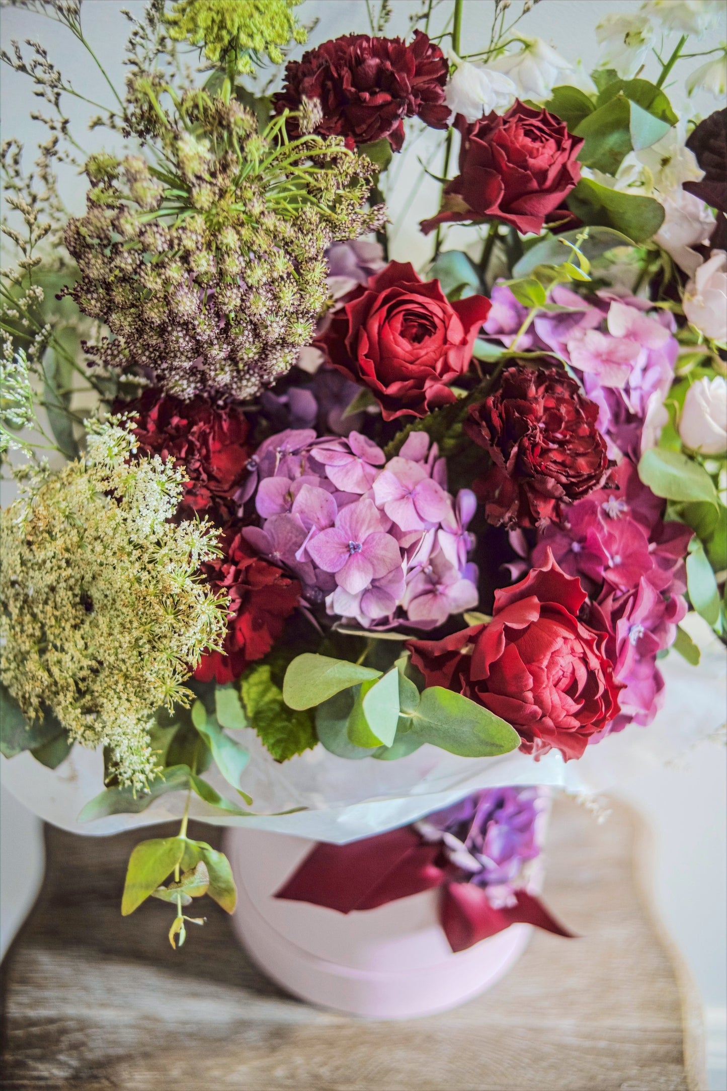 Details of the green and pink florals in a light pink hatbox