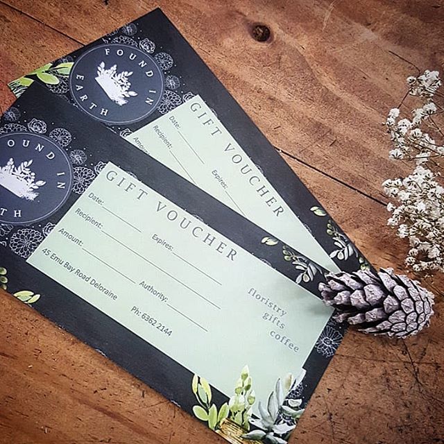 Photograph of two hardcopy gift vouchers for Found in Earth on a wooden surface