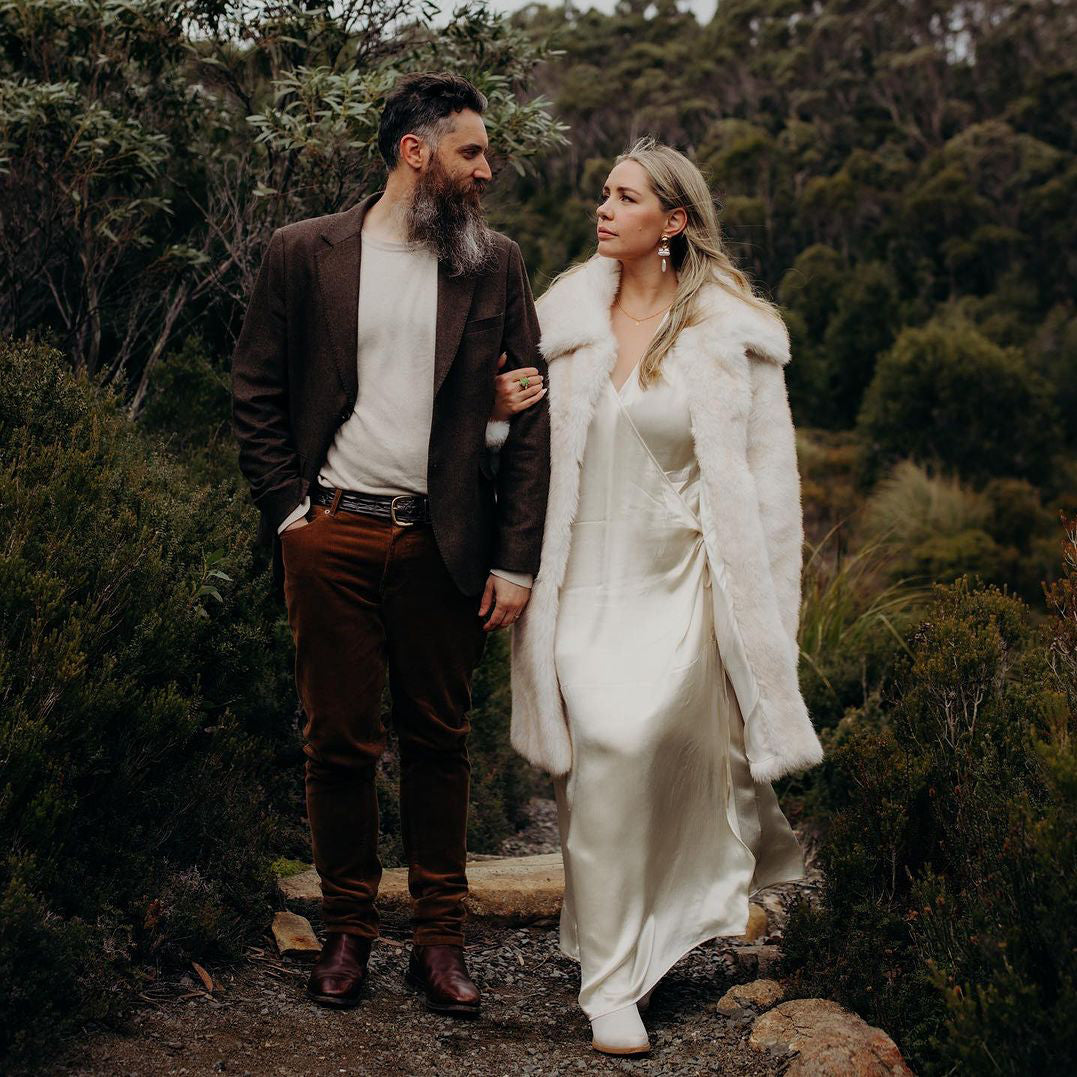 Photograph of a bride and groom standing in the Tasmanian bush, looking into each other's eyes