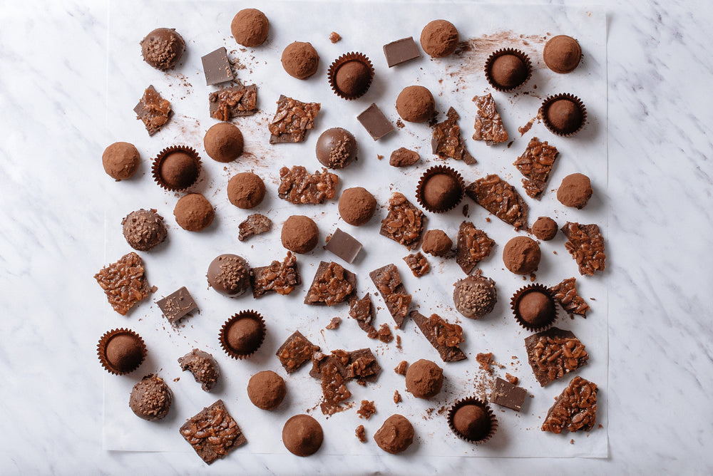 Photograph of an assortment of delicious chocolates sitting on a marble surface