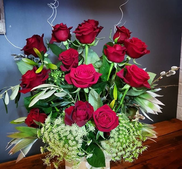 Picture of 12 Tasmanian long stemmed red roses and green foliage in a beautiful keepsake glass vase.